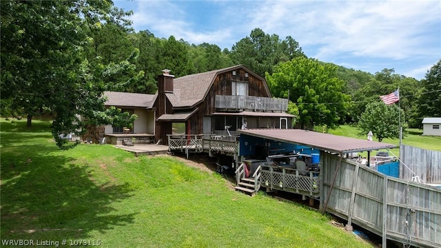 rear view of house featuring a deck and a yard