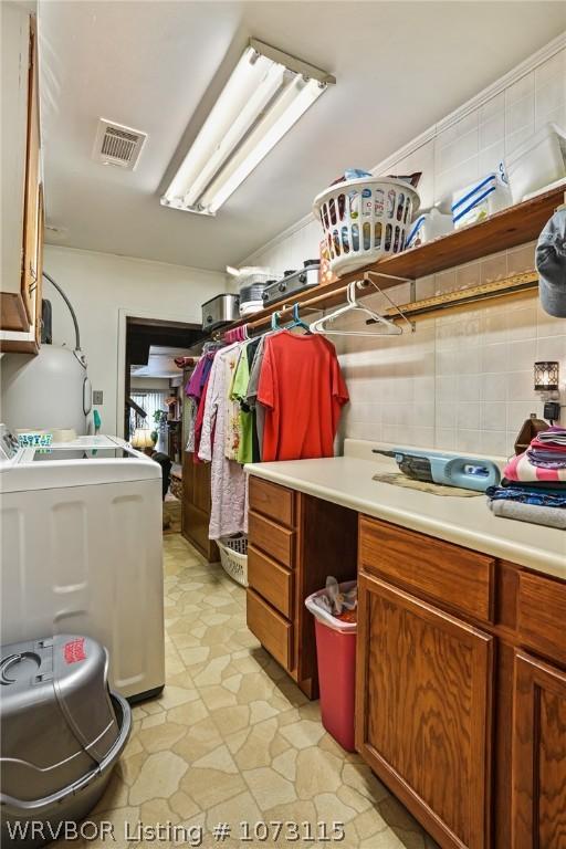 laundry area featuring washer / clothes dryer and cabinets