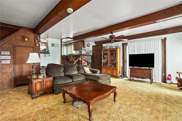 living room with beamed ceiling, ceiling fan, and light colored carpet