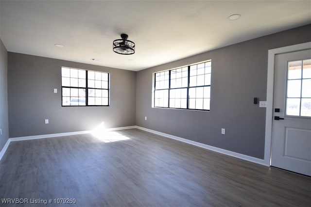 interior space featuring a healthy amount of sunlight, dark wood finished floors, and baseboards