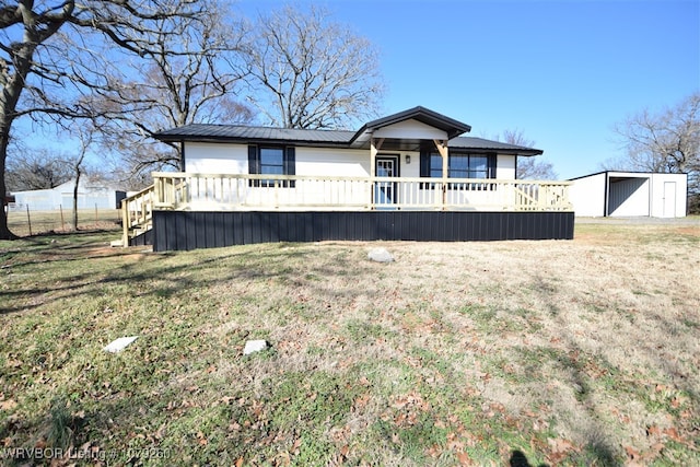 view of front of house with metal roof, a front lawn, and a deck