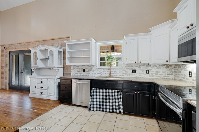 kitchen with white cabinetry, appliances with stainless steel finishes, sink, and backsplash