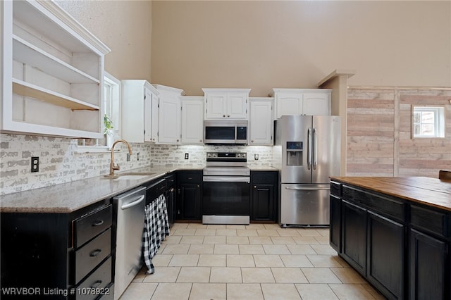 kitchen featuring butcher block countertops, sink, backsplash, stainless steel appliances, and white cabinets