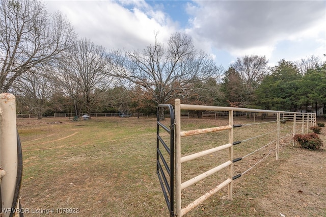 view of gate with a rural view and a lawn