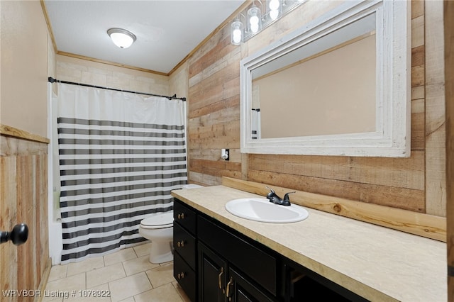 bathroom with tile patterned floors, toilet, crown molding, vanity, and wooden walls