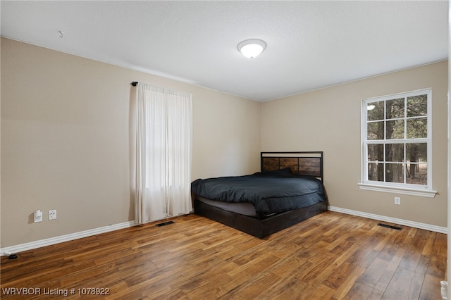 unfurnished bedroom with hardwood / wood-style flooring