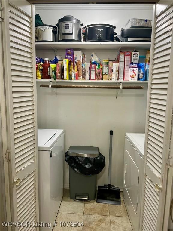 laundry room with washing machine and dryer and light tile patterned floors