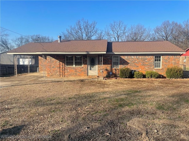 ranch-style house featuring a front lawn and a carport