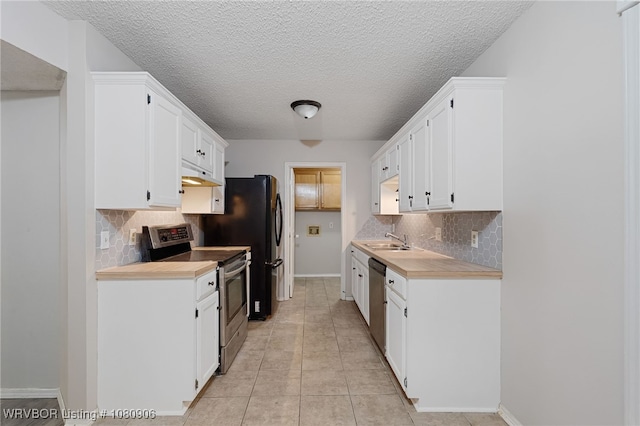 kitchen featuring stainless steel appliances, tasteful backsplash, light countertops, white cabinets, and a textured ceiling