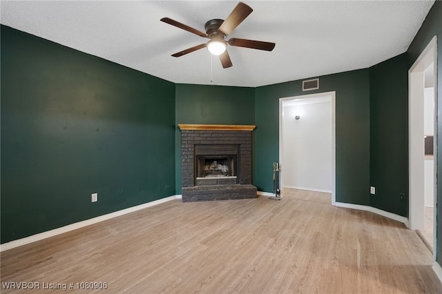 unfurnished living room with a ceiling fan, wood finished floors, a fireplace, and baseboards