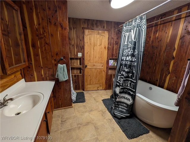 bathroom featuring wooden walls, a shower with curtain, a bathing tub, a textured ceiling, and vanity