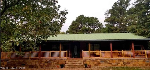 exterior space with a porch and metal roof