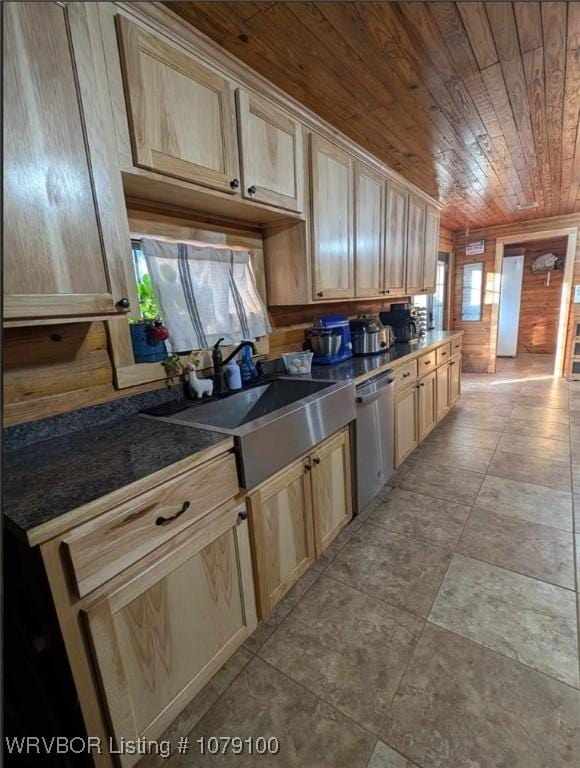 kitchen with stainless steel dishwasher, light brown cabinets, wood walls, a sink, and wooden ceiling