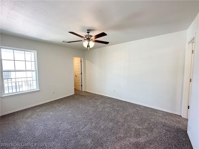 carpeted spare room with ceiling fan and a textured ceiling