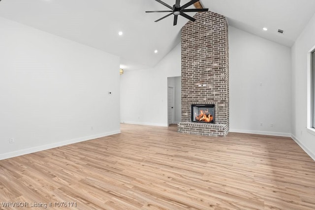 unfurnished living room with high vaulted ceiling, light hardwood / wood-style flooring, a brick fireplace, and ceiling fan