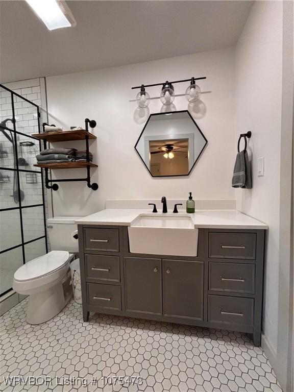 bathroom featuring tile patterned floors, vanity, toilet, and a shower with shower door