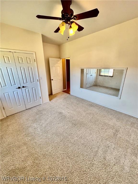 unfurnished bedroom with carpet, ceiling fan, and a closet