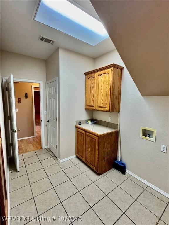 laundry room featuring light tile patterned flooring, cabinets, and washer hookup