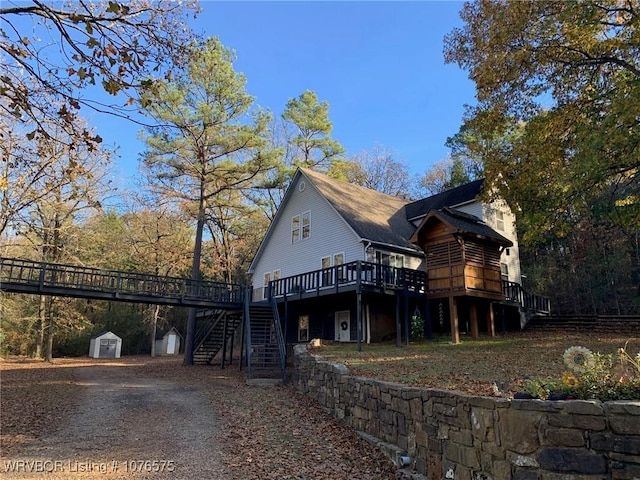 view of home's exterior featuring a storage shed and a wooden deck