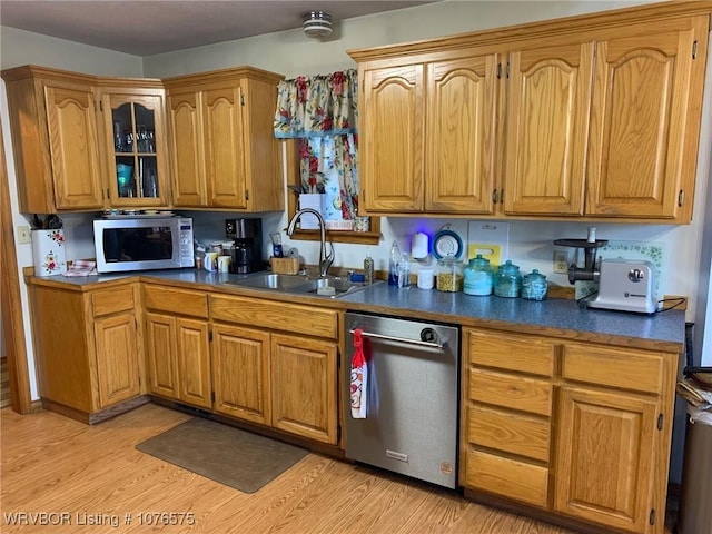 kitchen featuring sink, stainless steel dishwasher, and light wood-type flooring