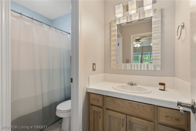 bathroom featuring toilet, vanity, and a ceiling fan