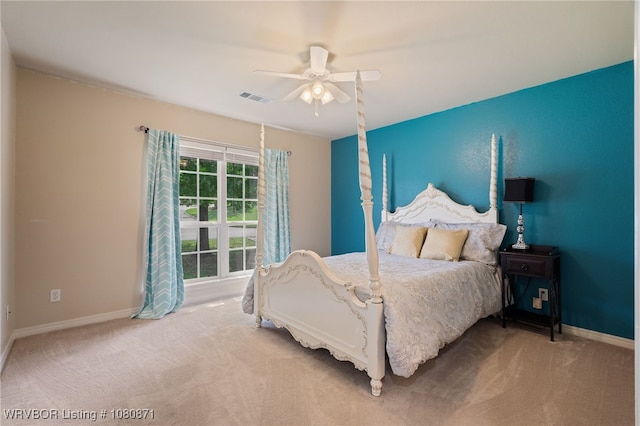 bedroom with light colored carpet, baseboards, and a ceiling fan