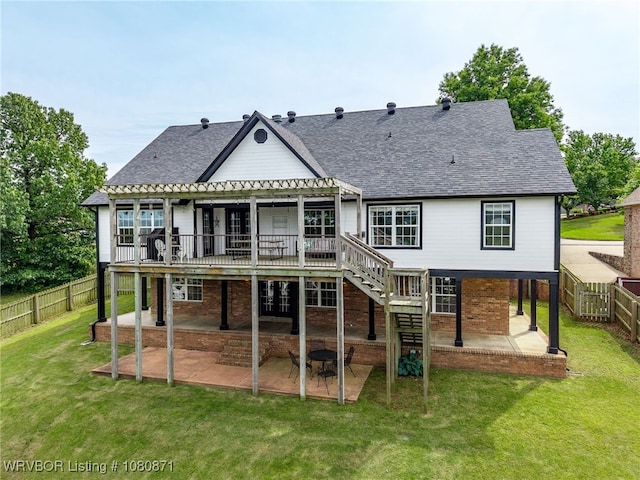 back of property with a patio area, a pergola, a shingled roof, brick siding, and a wooden deck