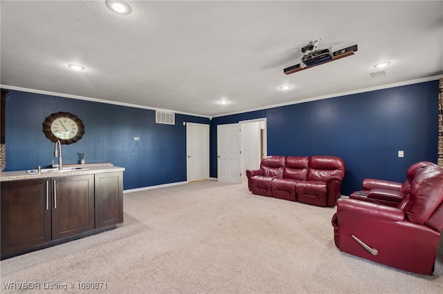cinema room featuring a sink, light carpet, ornamental molding, recessed lighting, and baseboards