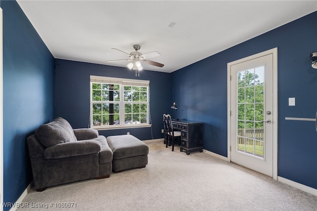 living area featuring carpet, a ceiling fan, and baseboards