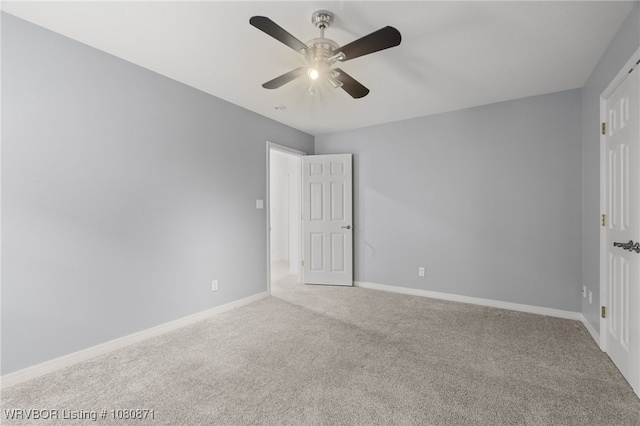 unfurnished room with carpet floors, a ceiling fan, and baseboards