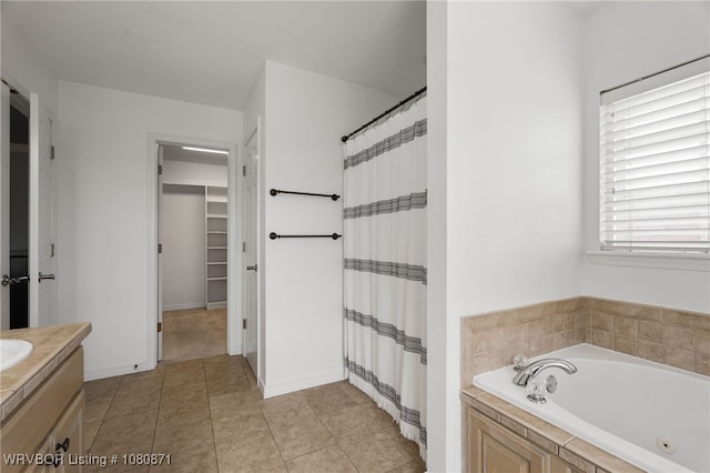 full bathroom featuring a walk in closet, a whirlpool tub, vanity, tile patterned flooring, and a shower with curtain