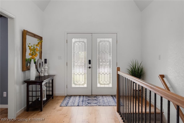 entrance foyer featuring vaulted ceiling, wood finished floors, french doors, and baseboards
