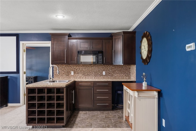 kitchen with black microwave, a sink, dark brown cabinetry, tasteful backsplash, and ornamental molding