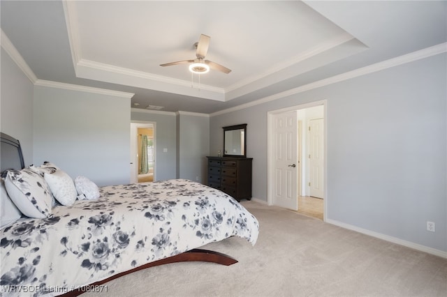 bedroom with a tray ceiling, light colored carpet, ornamental molding, a ceiling fan, and baseboards