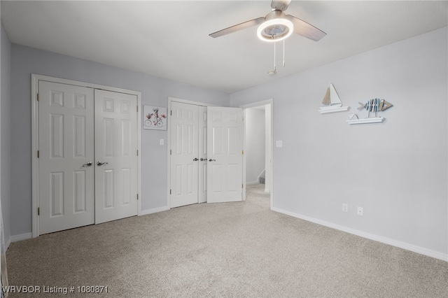 unfurnished bedroom with multiple closets, carpet, and baseboards