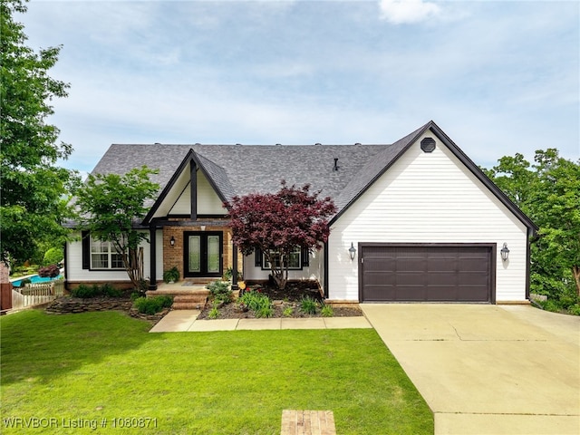 modern farmhouse style home with french doors, driveway, an attached garage, a shingled roof, and brick siding