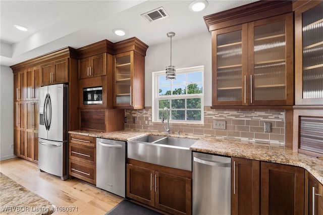 kitchen featuring stainless steel appliances, a sink, backsplash, pendant lighting, and recessed lighting