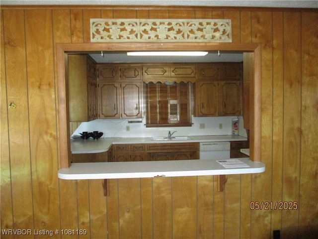 1501 18th St, Ozark, AR 72949 - kitchen with a sink, brown cabinets, white dishwasher, wood walls, and light countertops