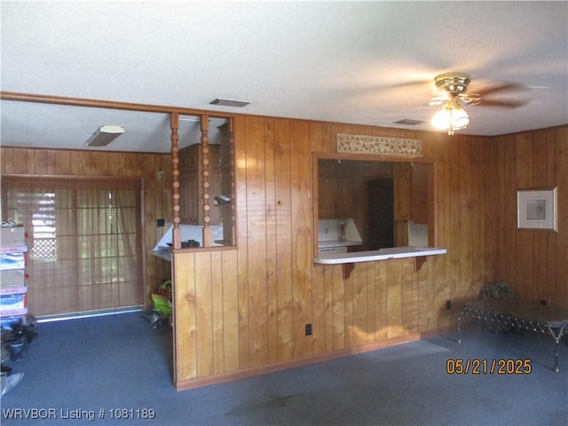 1501 18th St, Ozark, AR 72949 - unfurnished living room with wood walls, carpet, and a ceiling fan