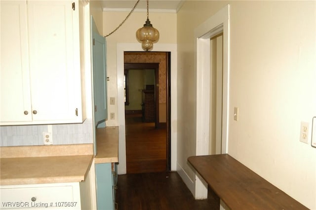 corridor featuring dark wood-type flooring and ornamental molding