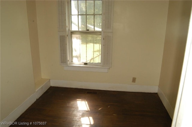 empty room with dark wood-type flooring