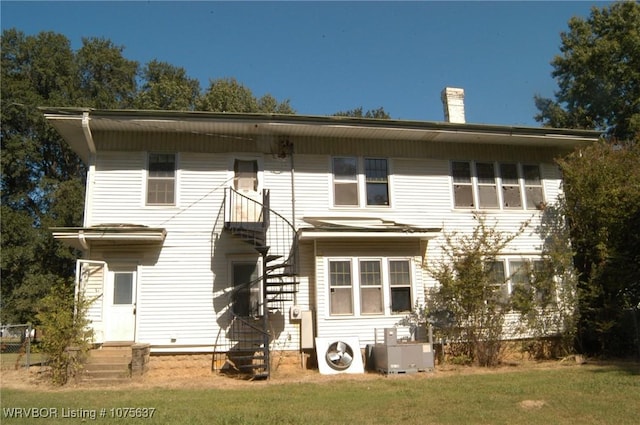 view of front facade with cooling unit and a front lawn