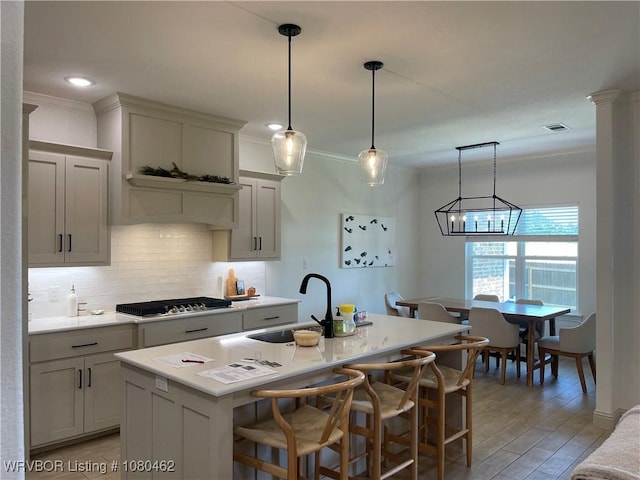 9121 Wayne Xing, Fort Smith, AR 72916 - kitchen featuring stainless steel gas stovetop, backsplash, light countertops, a sink, and a kitchen island with sink