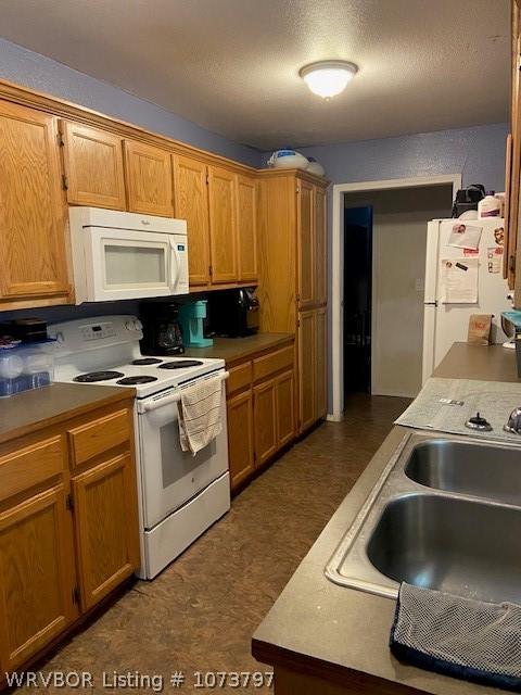 kitchen featuring white appliances and sink