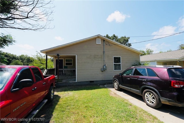 view of side of property featuring covered porch and a yard