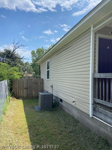 view of property exterior featuring a lawn and central AC unit