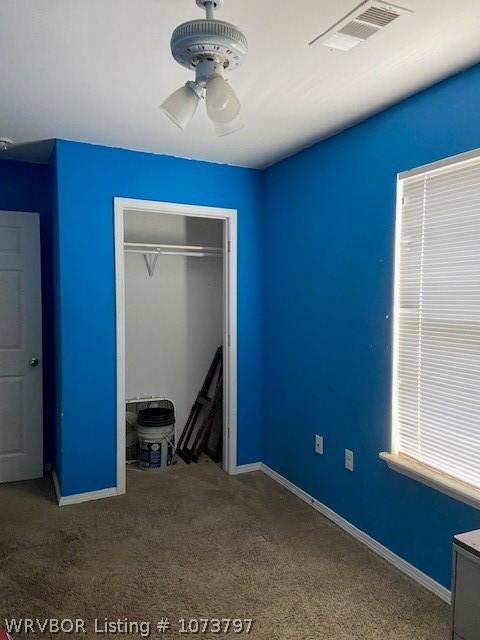 unfurnished bedroom with ceiling fan, carpet floors, and a closet