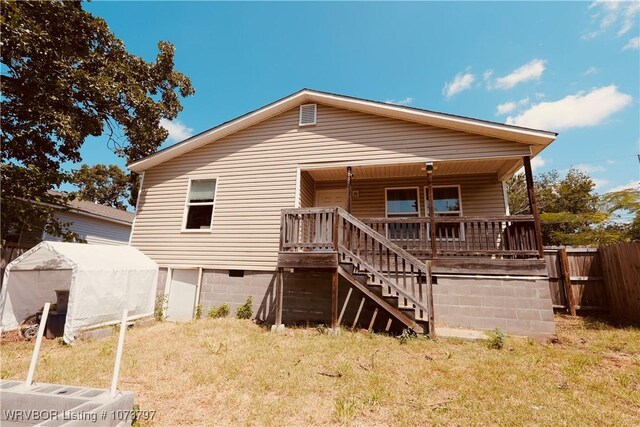 rear view of property with a lawn and a porch