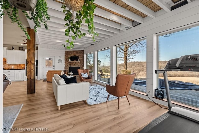 interior space featuring beamed ceiling and a stone fireplace