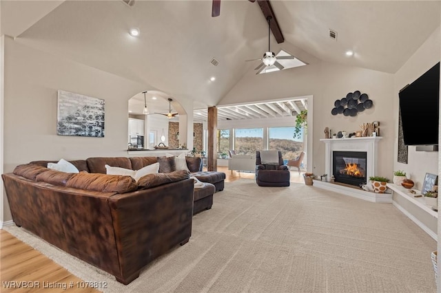 living room featuring ceiling fan, high vaulted ceiling, and beamed ceiling